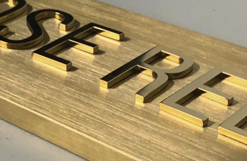close-up-brass-mirror-polished-letters-on-brushed-backing